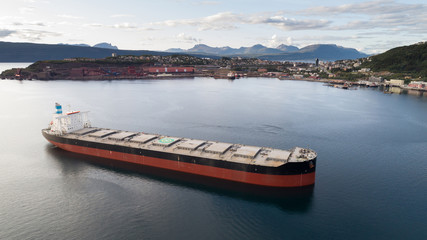 NORWAY, NARVIK - APRIL 15, 2019: Aerial shot of a iron ore cargo ship in Narvik bay, Narvik, Norway