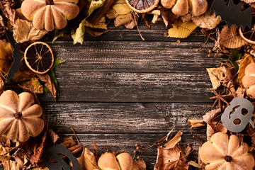 Frame border with autumn fall leaves on a dark wooden table