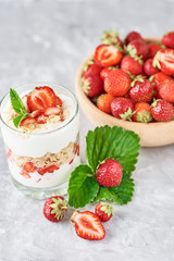 Strawberry granola or smoothie in glass and fresh berries in a wooden bowl. Healthy breakfast