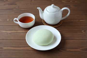お皿にのせた メロン パン 紅茶 木のテーブル