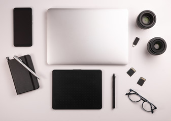 Top view of desktop for photographer or designer, with computer, table, coffee, notebook, mobile, memory cards