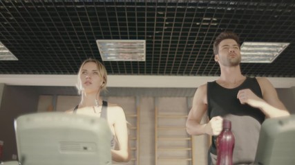 Sport couple training run on treadmill machine in fitness club.
