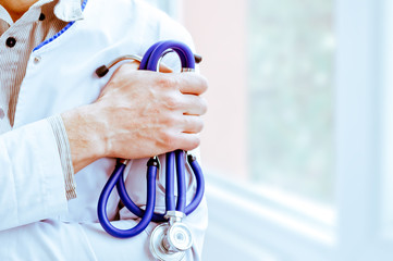 Male doctor holding a stethoscope in her hand with the blurred background