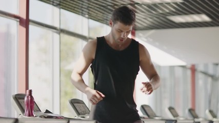 Fitness man running on treadmill machine in gym club.