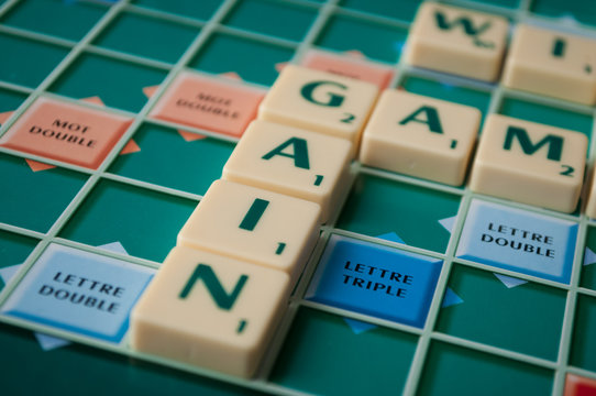 Closeup of plastic letters with word gain on Scrabble board game