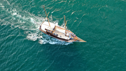 Aerial drone view of small vintage wooden schooner sailing in Balearic islands