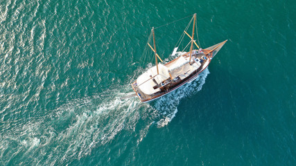 Aerial drone view of small vintage wooden schooner sailing in Balearic islands