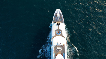 Aerial drone top view photo of luxury yacht, cruising in moderate speed in open sea with splash and...