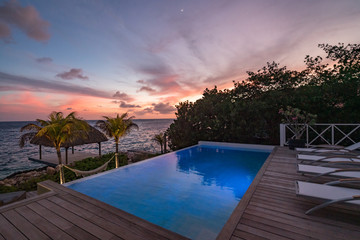 Sunset over the sea from a house and swimming pool