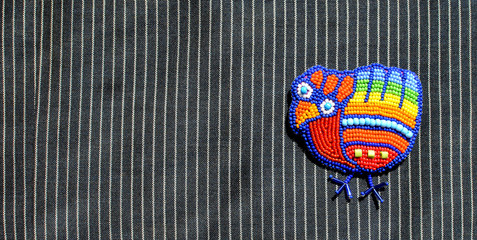 Trendy bead brooch, bright colors, on striped dress