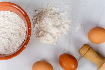 Rolling pin, cup of flour and eggs.