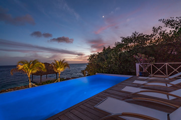 Sunset over the sea from a house and swimming pool