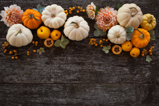 Wooden background with pumpkins and flowers