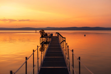 Beautiful sunset over lake Balaton with a pier and silhouettes