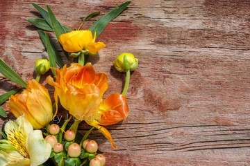 Horizontal image of fresh cut flowers and greenery on a weathered wood background with copy space