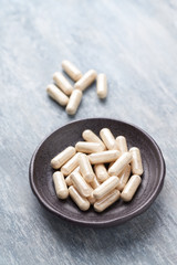 Iron capsules. Concept for a healthy dietary supplementation. Bright wooden background. Close up. Copy space.  