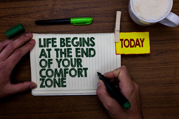 Word writing text Life Begins At The End Of Your Comfort Zone. Business concept for Make changes evolve grow Man holding marker notebook clothespin reminder wooden table cup coffee