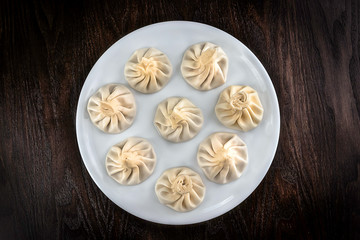 Khinkali on a white plate. Traditional Georgian dumplings. National dish of Georgian cuisine. Top view flat lay