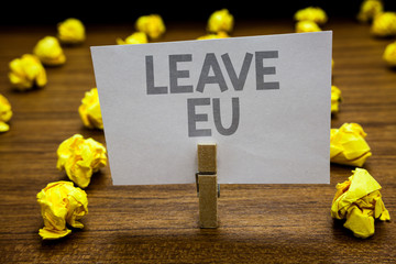 Fototapeta premium Word writing text Leave Eu. Business concept for An act of a person to leave a country that belongs to Europe Clothespin hold holding paper idea reminder crumpled papers several tries