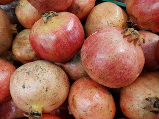 A pile of red pomegranates closeup.