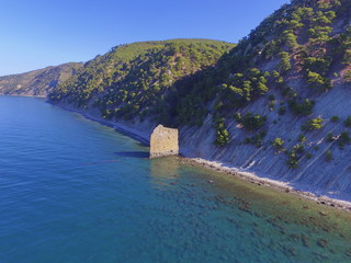Parus rock with the rocky coast of Black sea. Clear water and a high slope covered with pine trees. View from above. Krasnodar region. Russia
