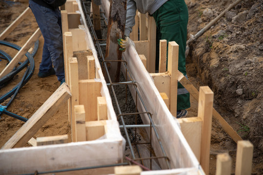 Workers pour concrete into the foundation