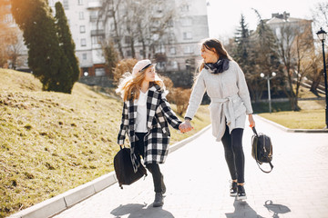 Beautiful girls in a park. Friends have fun in a spring city