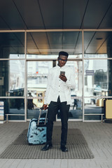 Fototapeta premium Handsome black man in a city. Businessman in a white shirt