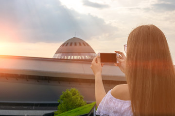 Girl makes a photo on the phone at sunset. Travel concept