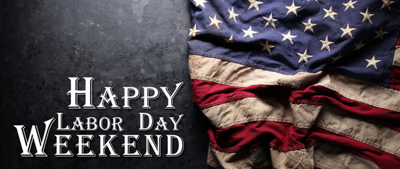 Fototapeta na wymiar US American flag on worn black background. For USA Labor day celebration. With Happy Labor Day Weekend text.