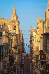 Fototapeta na wymiar Old Narrow Street With Traditional Closed Wooden Balconies In Valletta city, Malta
