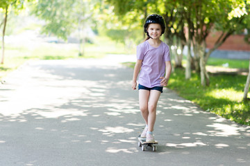 A little girl skates on an alley. And smiles.