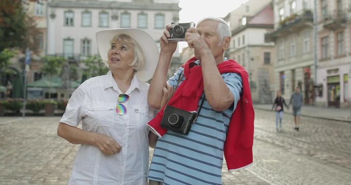 Senior male and female tourists makes a photo while traveling in Lviv, Ukraine