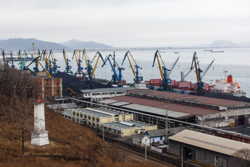 Fototapeta premium Coal terminal in the sea trading port of the sea city of Nakhodka. Coal collapse on the coast of a large city.