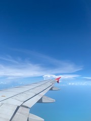 Obraz premium wing of airplane flying above clouds