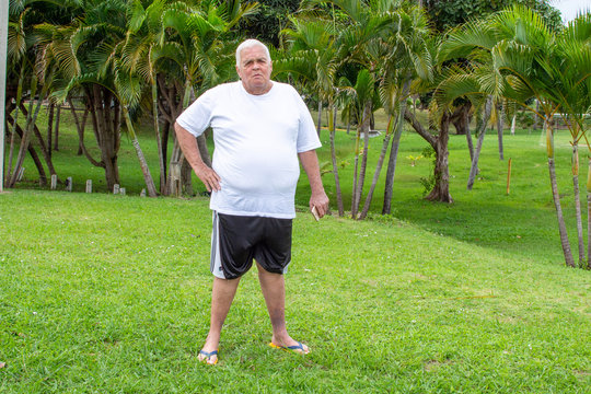Fat old man walks exercises nature park
