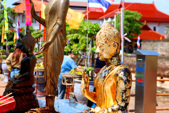The golden yellow Buddha statue located in the middle of the courtyard in the tradition that people are worshiping and watering to worship.Thailand,Lumphun : 18 Jun.19