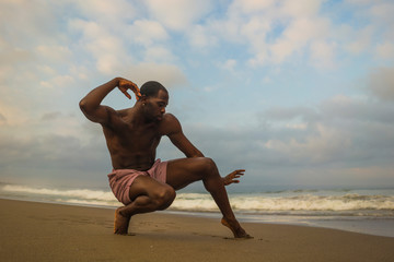 Fototapeta na wymiar contemporary dance choreographer and dancer doing ballet beach workout . a young attractive and athletic black African American man dancing in dramatic performance