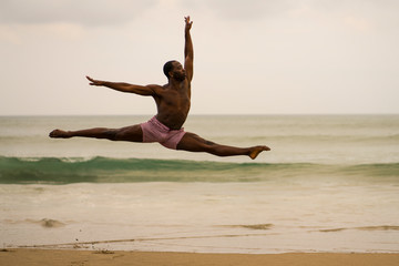 contemporary dance choreographer doing ballet beach workout . young attractive and athletic black...