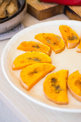 Baked roasted pumpkin slices on plate.