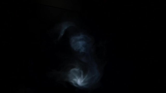 Blue and grey smoke on a black background.
