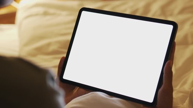 Blank digital tablet in the hands of Asian women, Tablet computer's white screen on bed in night time