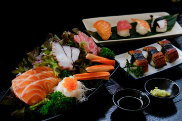 Sashimi set and many sushi set on black stone table