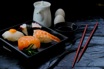 Sushi set with soy sauce and chopsticks on a dark background.japanese food