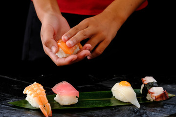 Closeup hands of japanese chef making sushi at restaurant