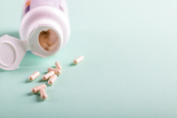 Pills, tablets and bottle on turquoise background. Copy space for text