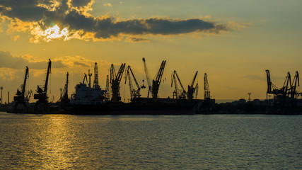 Obraz premium Colorful sunset over sea port and industrial cranes, Varna, Bulgaria