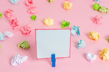 Colored crumpled papers empty reminder pink floor background clothespin