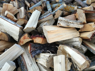 Heap of cut firewood. Sawn and cut tree trunks drying outdoors in the sun before being stacked and stored.