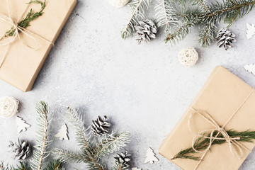 Christmas background. Christmas fir tree branches, gifts, pine cones on wooden white rustic background. Flat lay, top view. Copy space. Banner backdrop composition